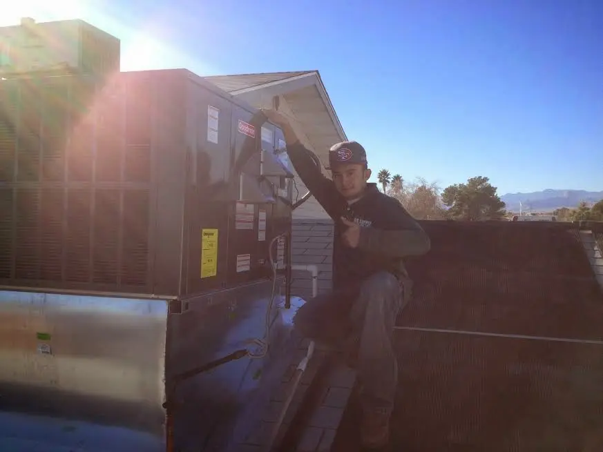 HVAC technician performing AC Tune-Up on a rooftop unit in Estacada